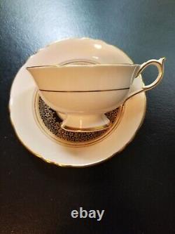 Tasse à thé Paragon beige avec bord festonné en bleu cobalt et anneau doré au centre floral